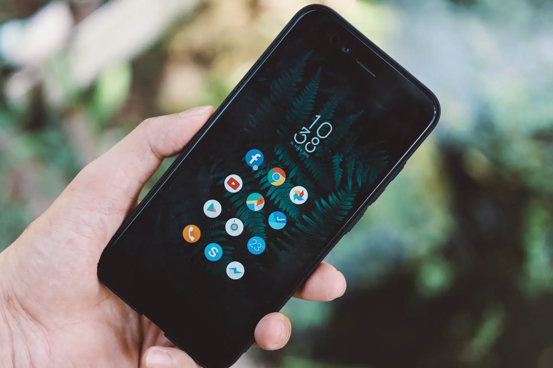 Dłoń trzymająca smartfon z ekranem aplikacji